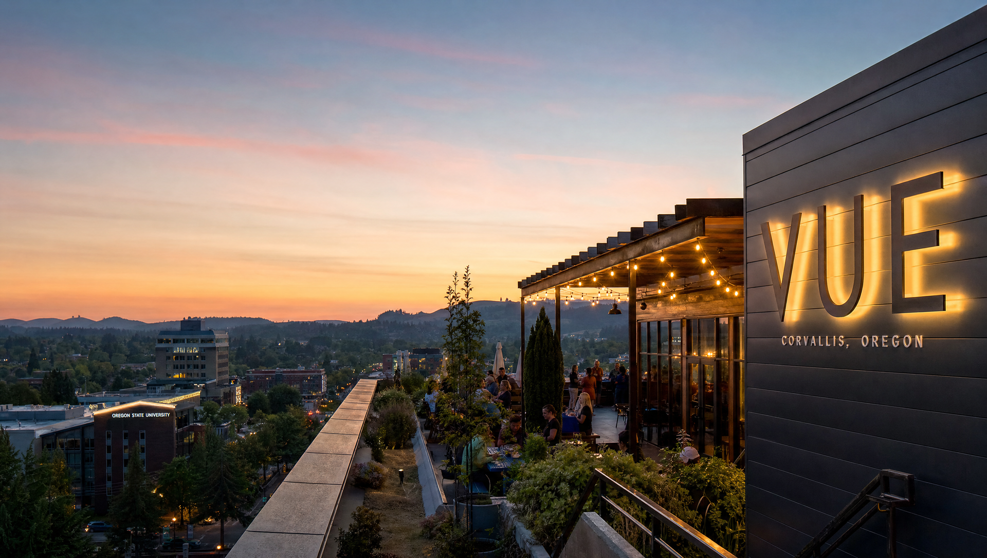 Rooftop restaurant terrace at sunset with glowing VUE sign and city skyline views