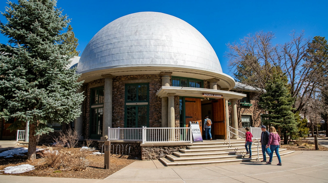 White-domed observatory building with people walking outside on a sunny day