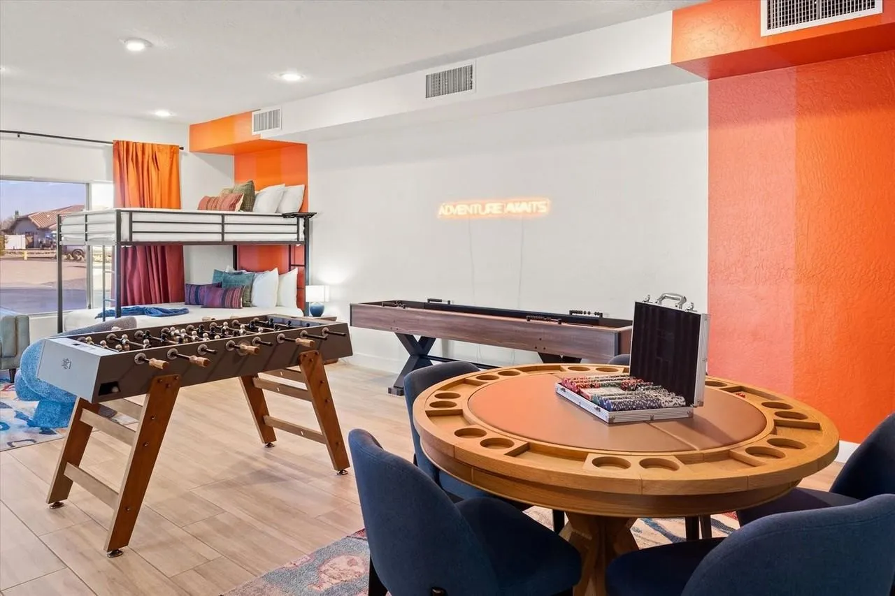Bright modern game room with pool table, foosball, and a round table with chairs