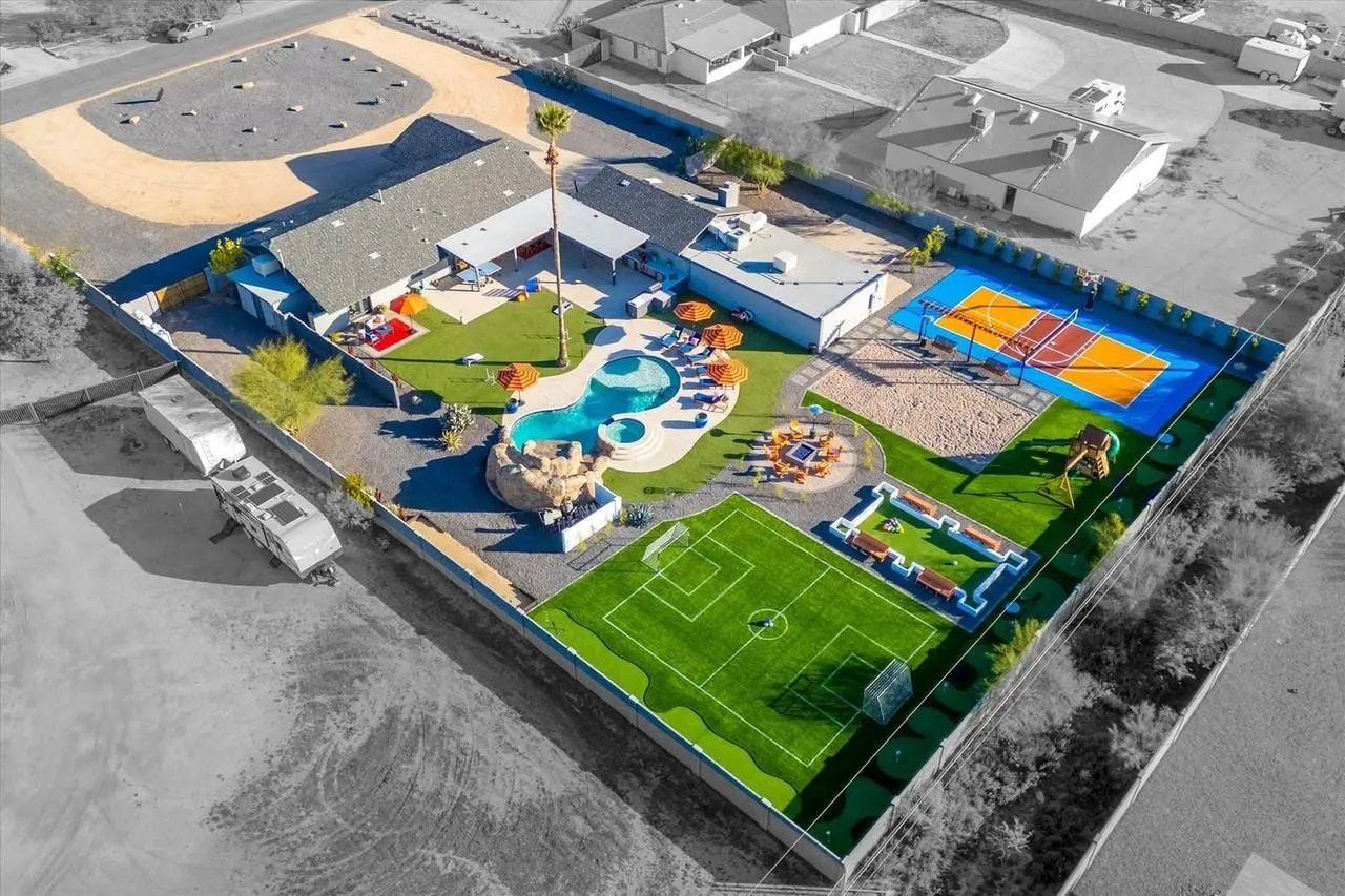 Aerial view of a colorful playground and sports courts beside a building.