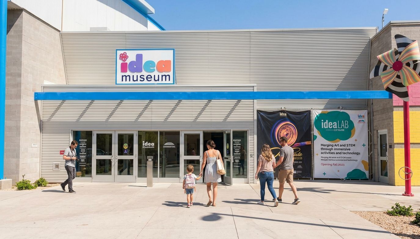 People walk toward the entrance of the bright, modern building with a large 