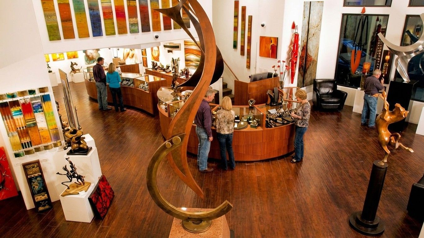 Bright boutique interior with colorful displays, curved wooden sculpture, and people browsing at counters