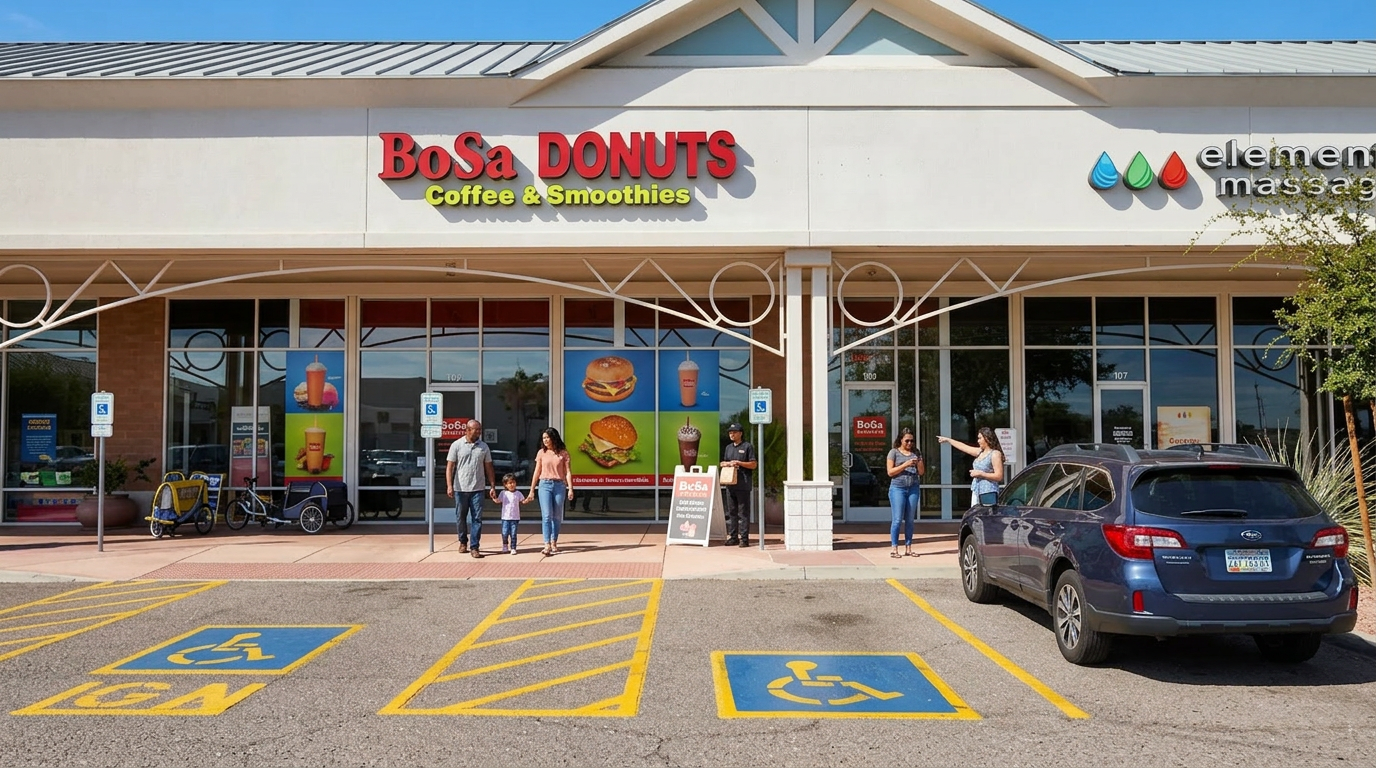 Strip mall storefront with a donut shop and law office, blue car parked outside, accessible parking spaces in front
