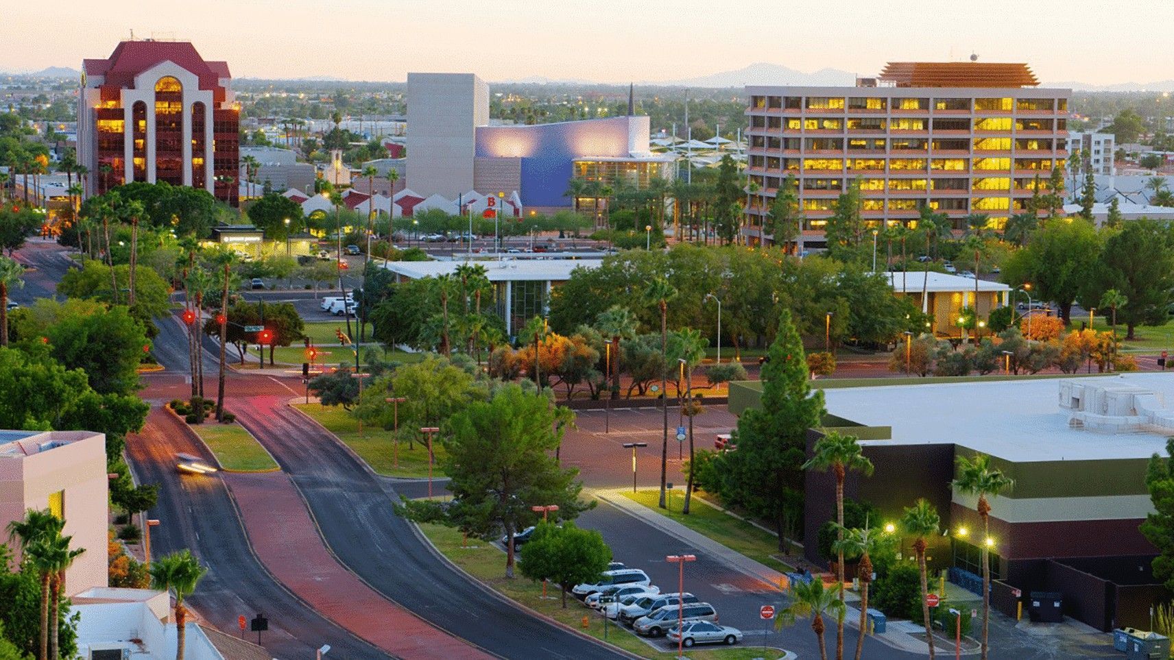 City skyline at dusk with buildings and trees.