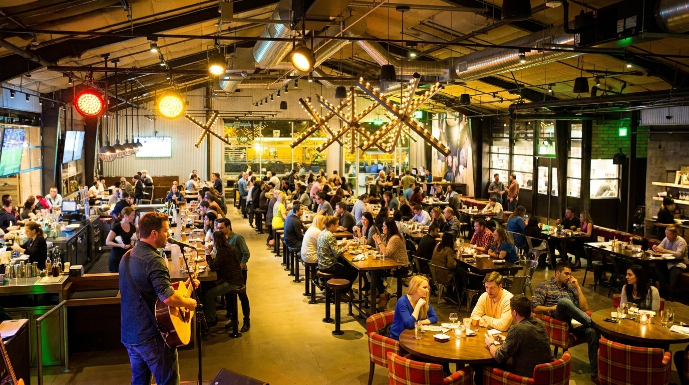 Crowded indoor restaurant with many diners at tables under warm lighting