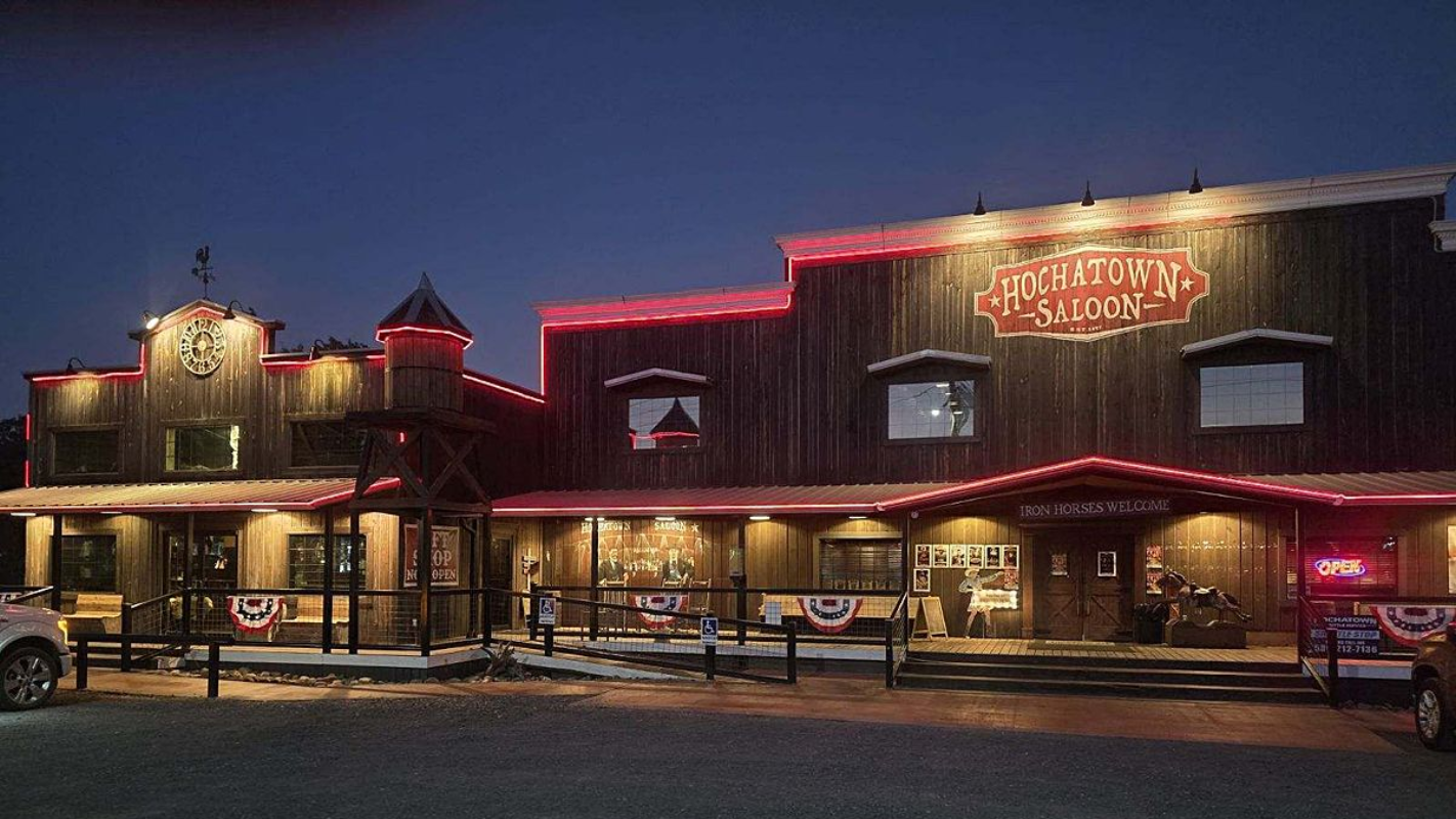 Wooden building at dusk with red lights, possibly a restaurant or saloon.