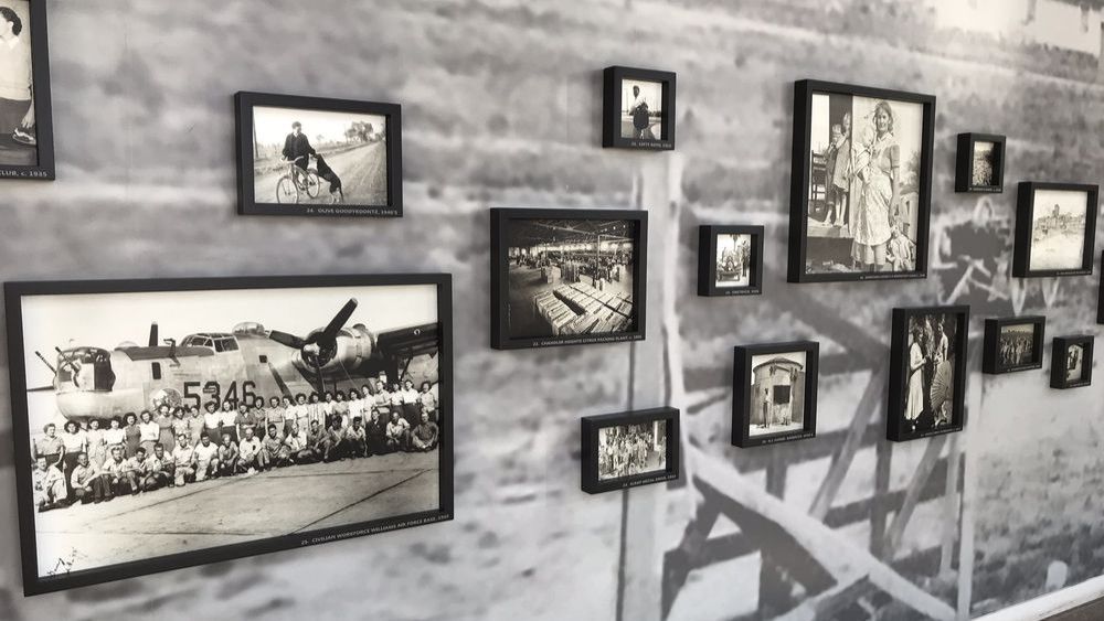 Black and white framed photographs displayed on a wall with a cityscape background.