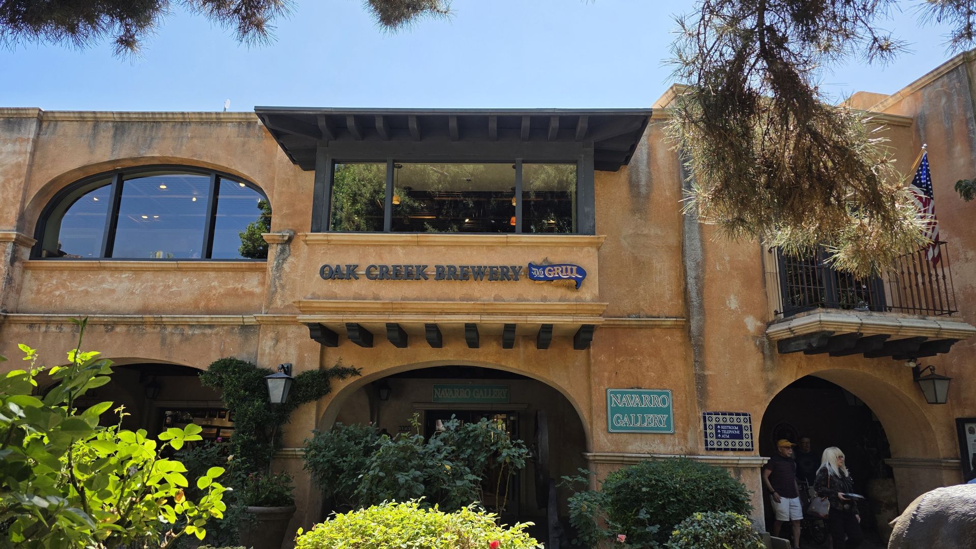 Oak Creek Brewery building with a tan facade and large windows under a blue sky.