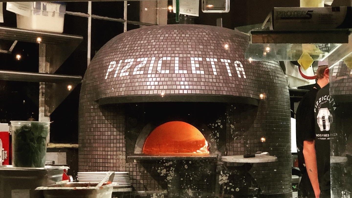 Brick pizza oven labeled 