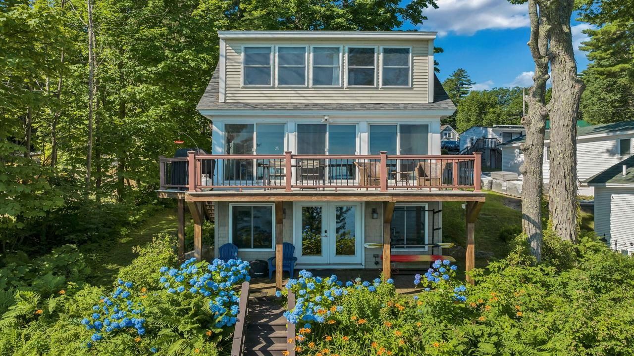 Managed NH Vacation Rental Exterior New Hampshire vacation rental home exterior with garden, deck, and lake access.