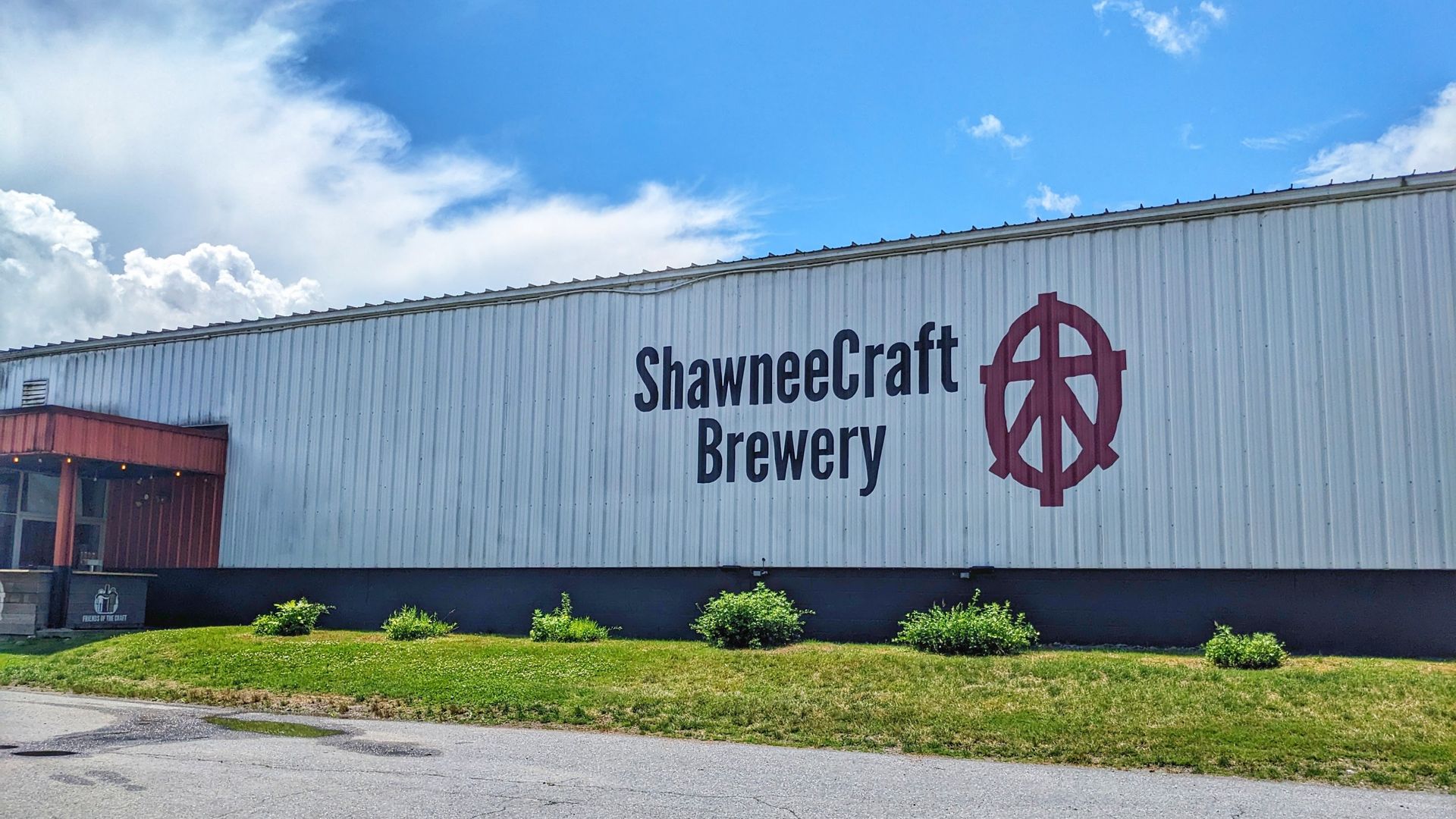 A large, white industrial building with a logo and the text 