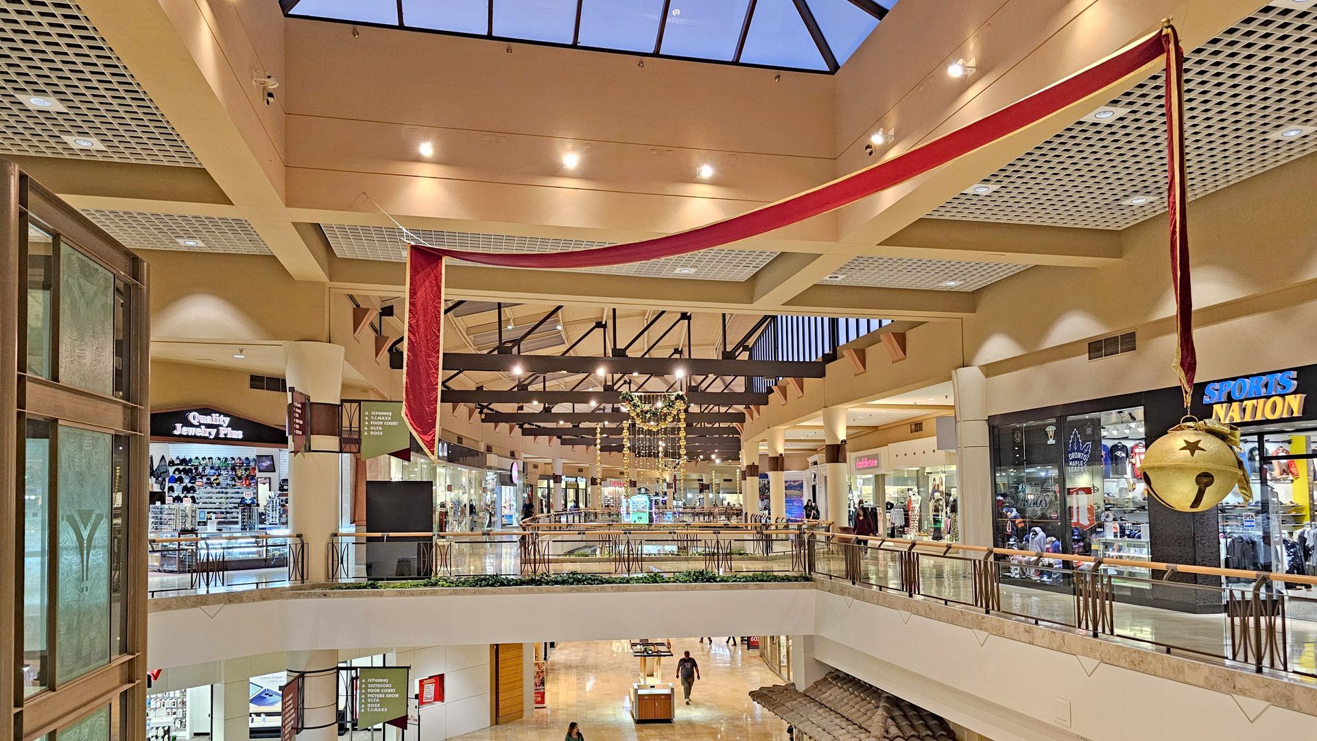 Interior of a shopping mall with multiple levels, decorated for the holidays.
