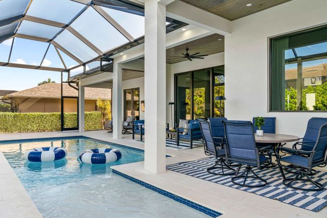 A large swimming pool with a table and chairs next to it.
