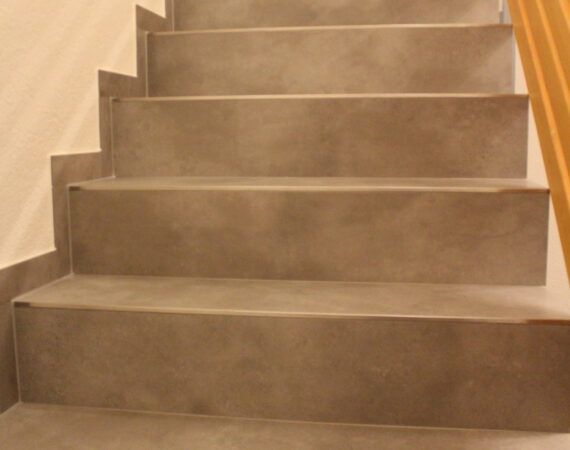 Betontreppe mit fünf Stufen, neutrale Farbtöne, die nach oben führt.