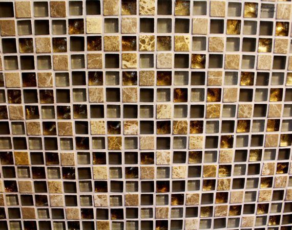 Nahaufnahme eines Mosaikfliesenmusters mit kleinen, quadratischen Fliesen in Braun- und Goldtönen.