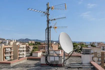 Antenas terrestre y parabólica en la cubierta de un edificio.
