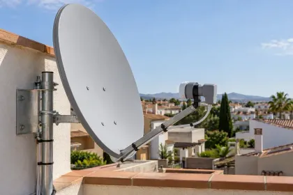 Antena parabólica con LNB fijada junto a una terraza.