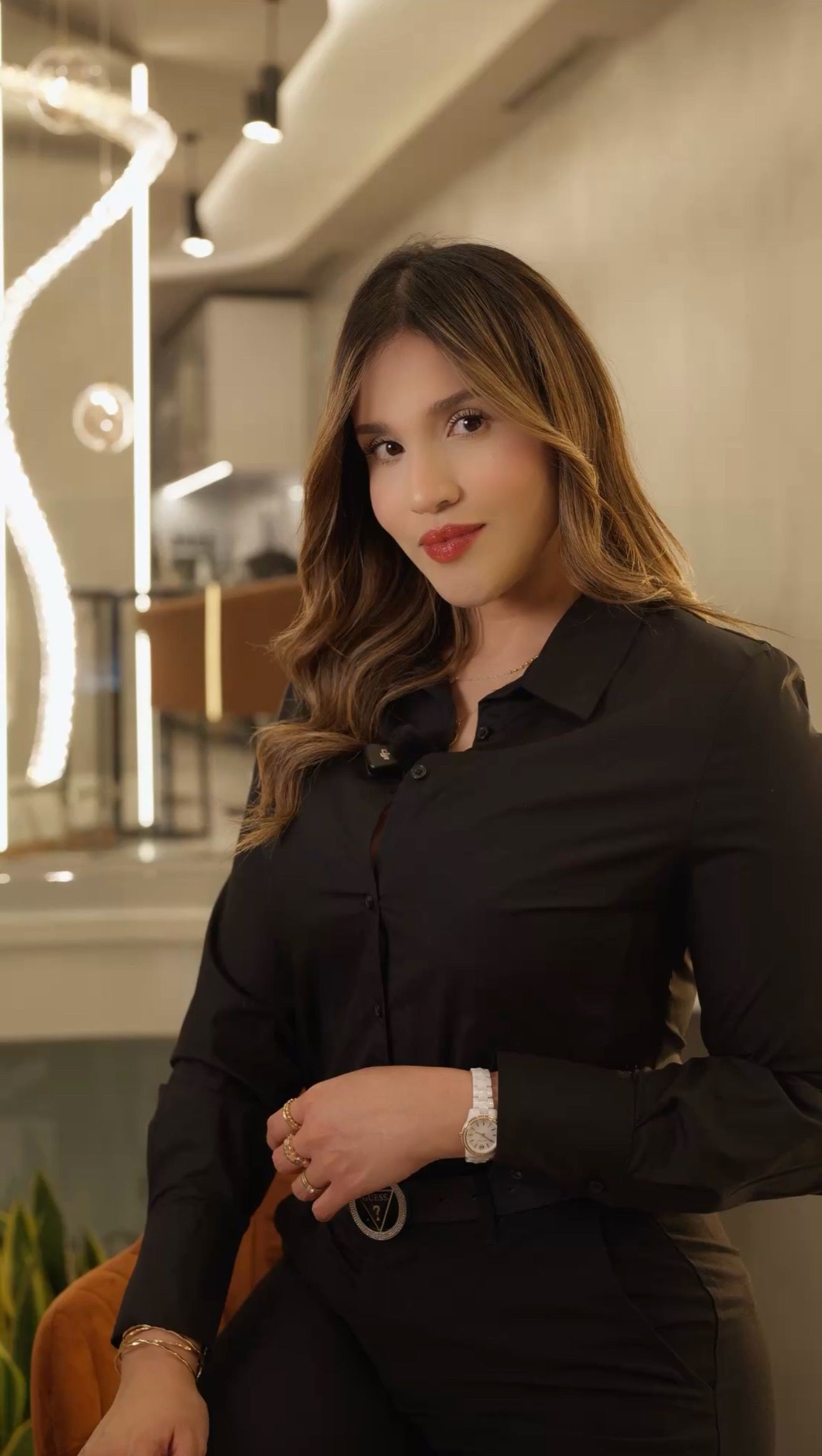 Una mujer con una bata blanca sonríe para la cámara.