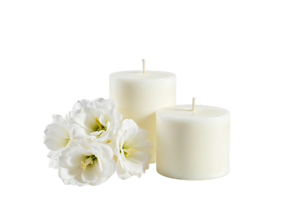 Deux bougies piliers blanches et des fleurs blanches sur fond blanc.