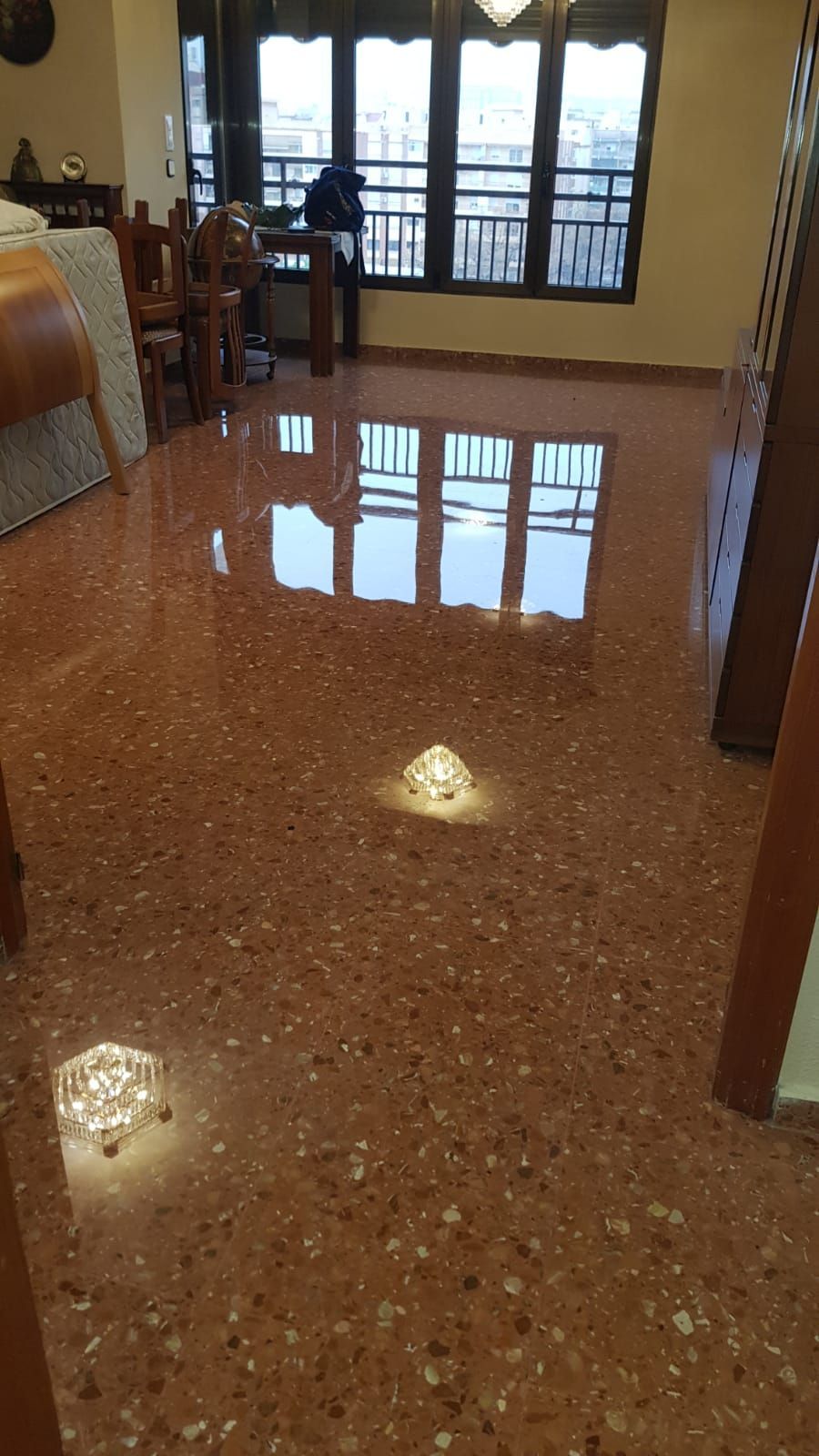 Una sala de estar con suelo de mármol y un reflejo de un edificio en el suelo.