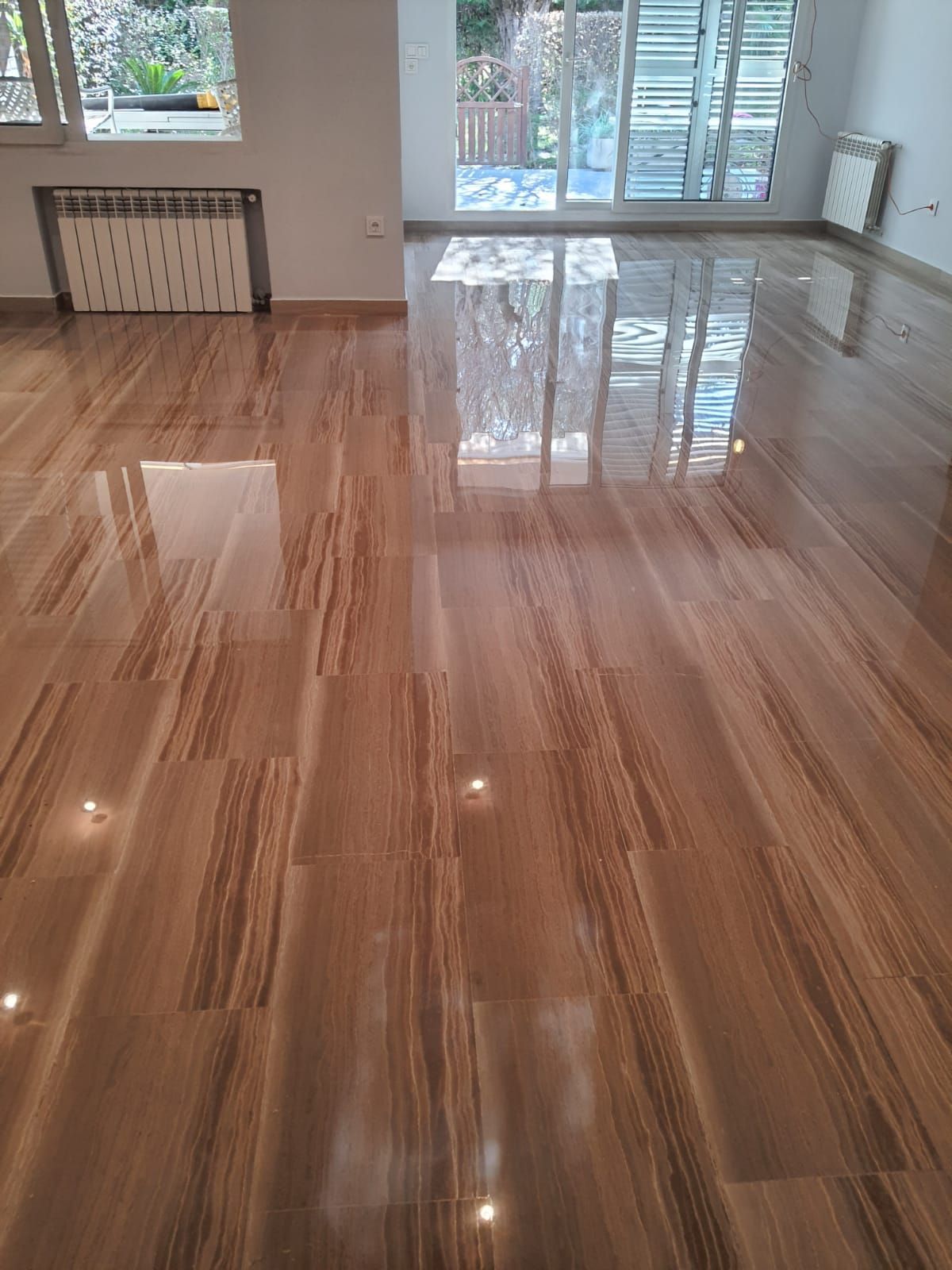 Una sala de estar con piso de madera y una puerta corrediza de vidrio.