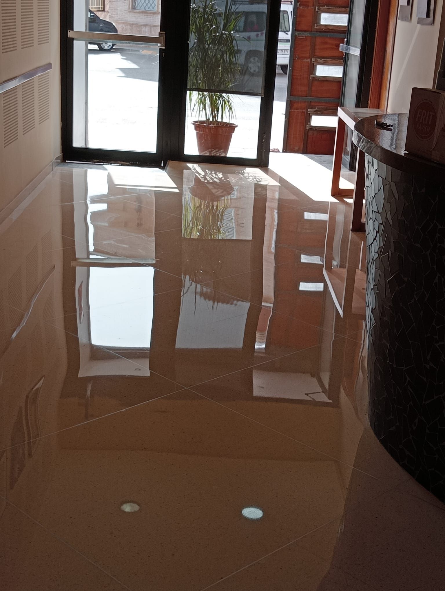 Un pasillo con el reflejo de un edificio en el suelo.