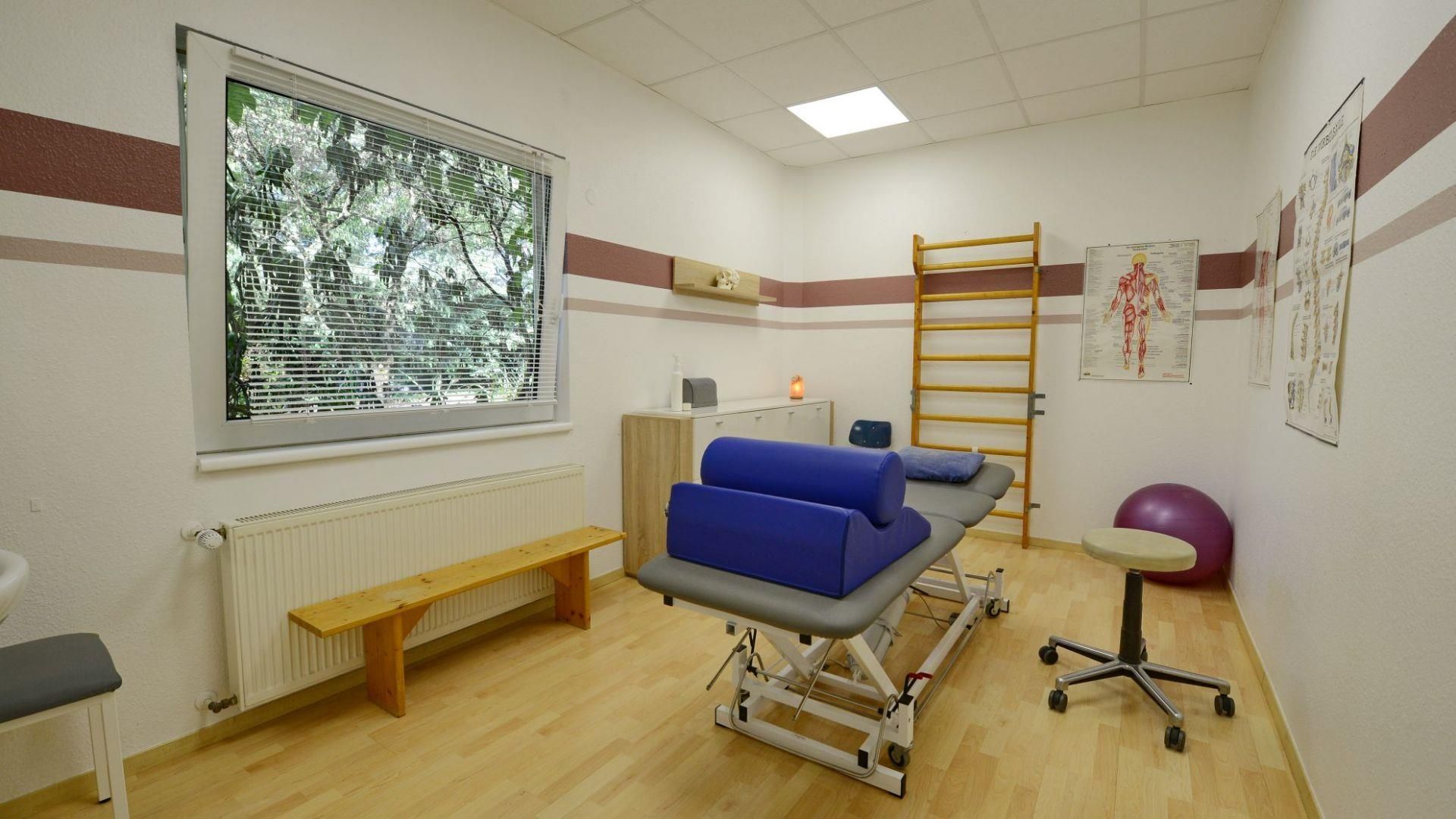 Ein Physiotherapieraum mit einem Tisch und einer Bank