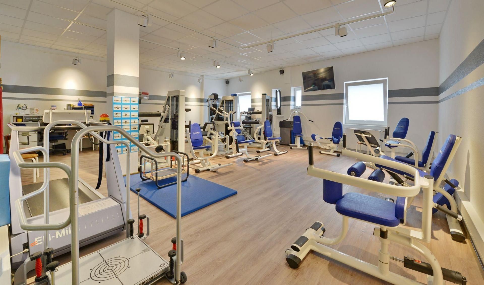 Ein Fitnessstudio mit vielen Trainingsgeräten, darunter ein Laufband