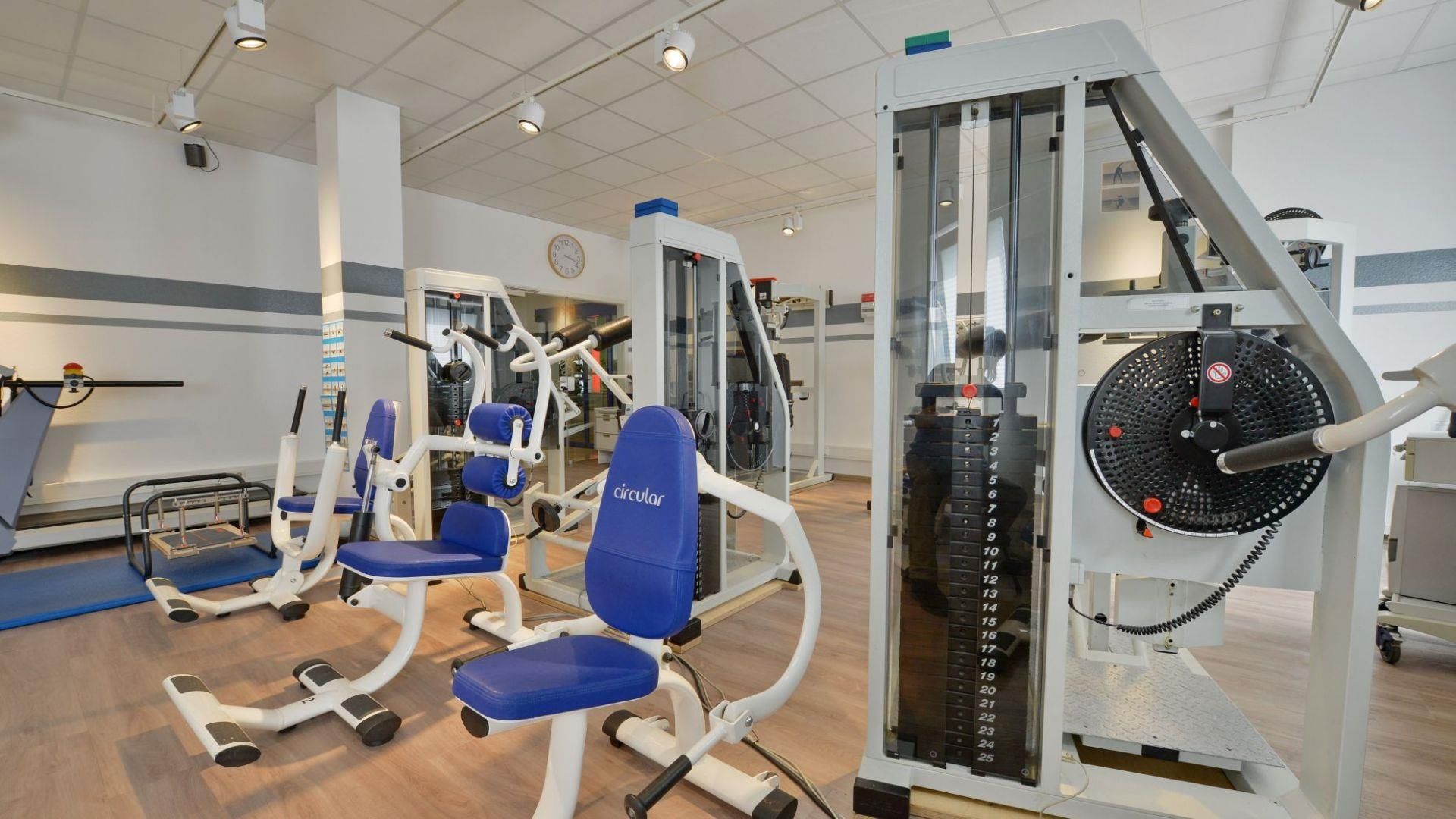 Ein Fitnessstudio mit einem blauen Stuhl in der Mitte