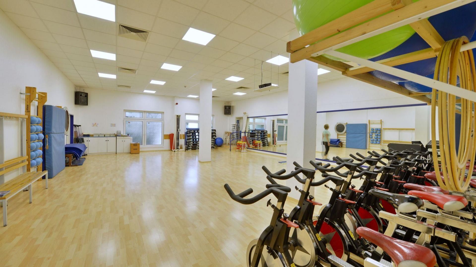 In einem Fitnessstudio stehen eine Reihe Heimtrainer