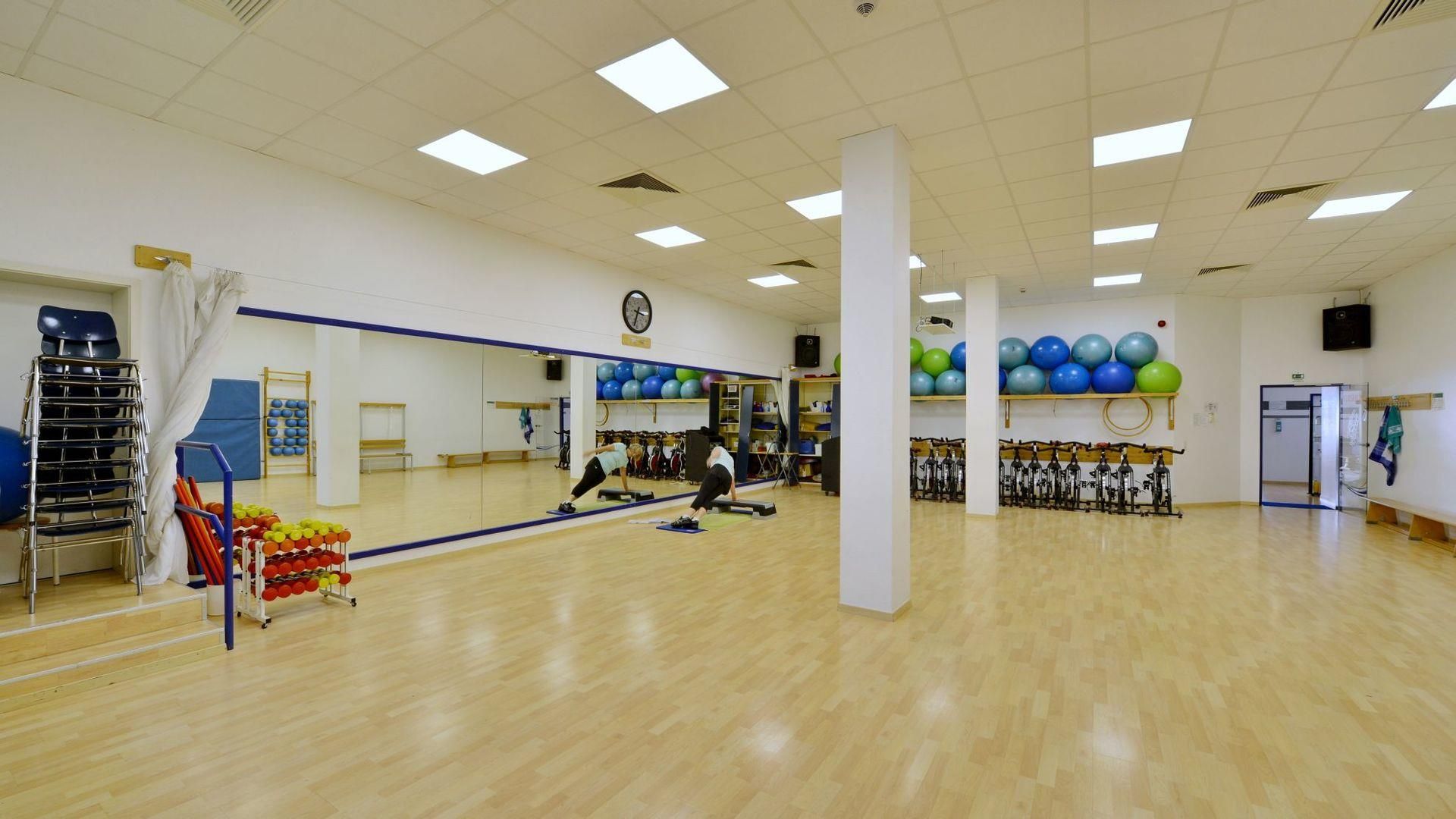 Ein Fitnessstudio mit vielen Trainingsgeräten und einem großen Spiegel