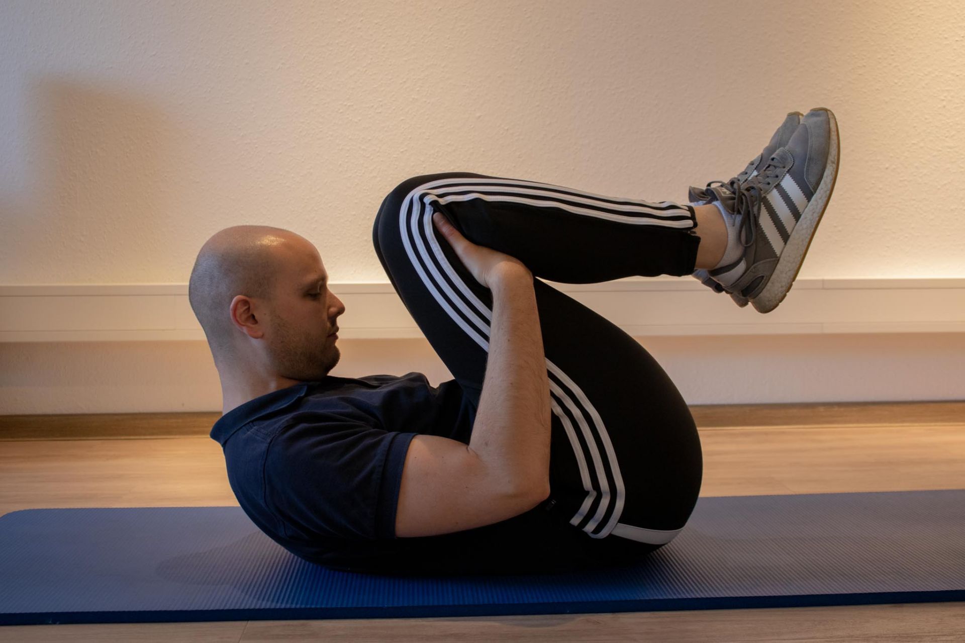Ein Mann macht Crunches auf einer blauen Matte