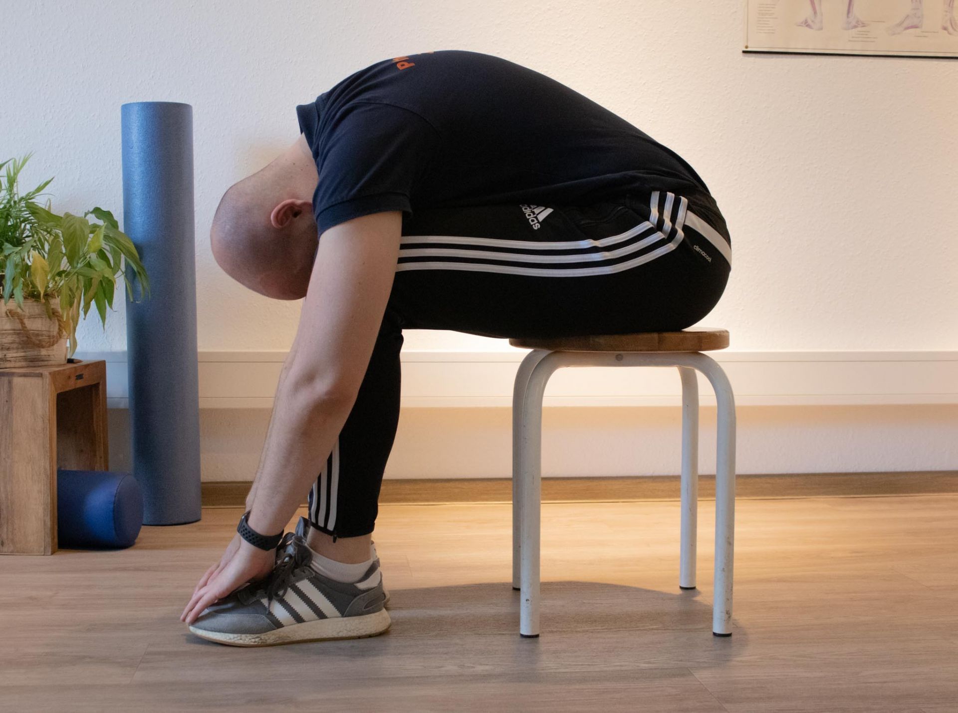 Ein Mann sitzt mit gesenktem Kopf auf einem Hocker