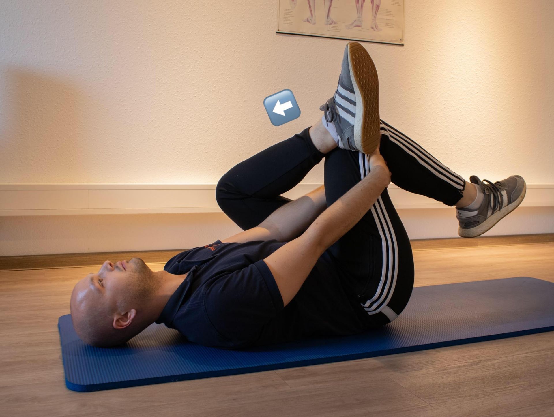 Ein Mann streckt seine Beine auf einer blauen Matte aus