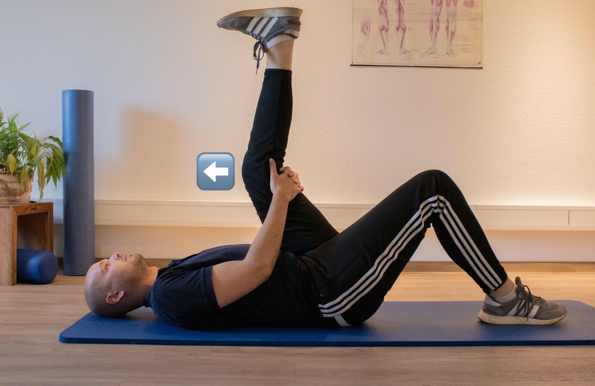 Ein Mann liegt auf einer blauen Matte und streckt sein Bein aus