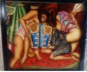 Figuras desnudas rodean un objeto decorativo azul sobre tela roja, encerrado por un borde enmarcado.