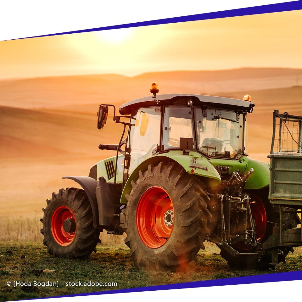 Traktor pflügt das Land in der Abendsonne und wird von [company_name] begleitet