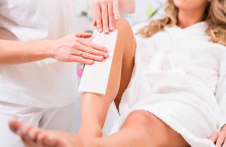 Eine Frau lässt sich in einem Schönheitssalon die Beine wachsen.