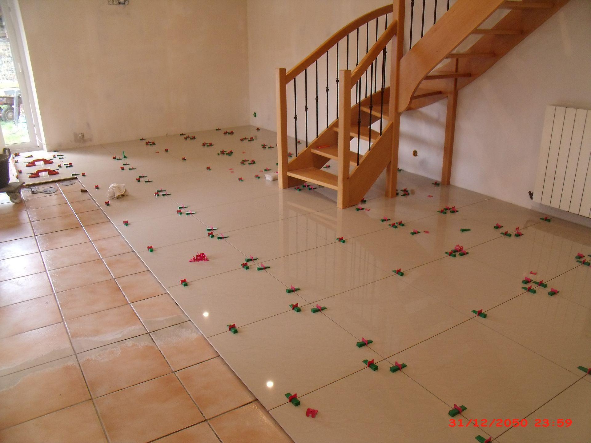 Pose de carrelage en cours de réalisartion dans un salon