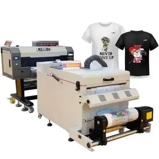 Oficina de impressão com grandes impressoras de tecido e estampas coloridas dispostas sobre mesas.