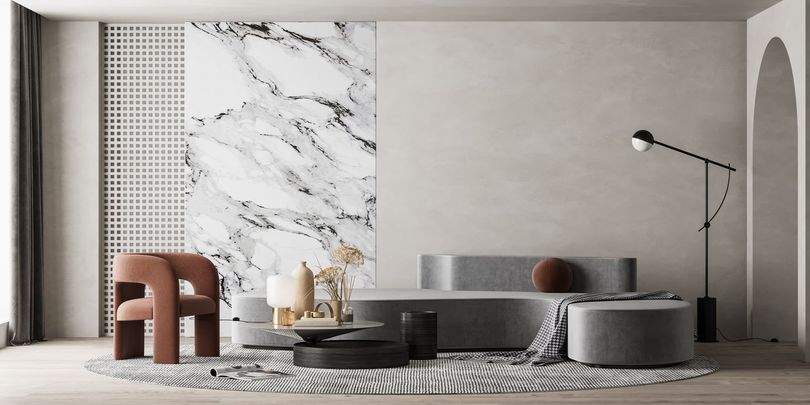 Salon minimaliste avec un mur d'accent en marbre, un canapé, des poufs ronds et un lampadaire.