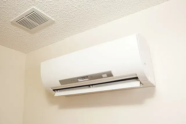 Un acondicionador de aire blanco cuelga del techo de una habitación.