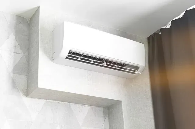 Un acondicionador de aire blanco cuelga del techo de una habitación.