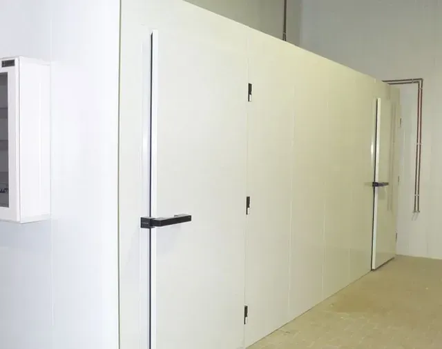 Una habitación con muchas paredes y puertas blancas.