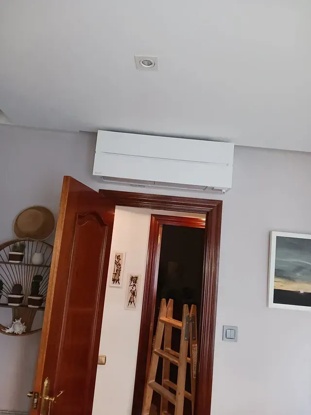 Una habitación con una escalera y un cuadro en la pared.