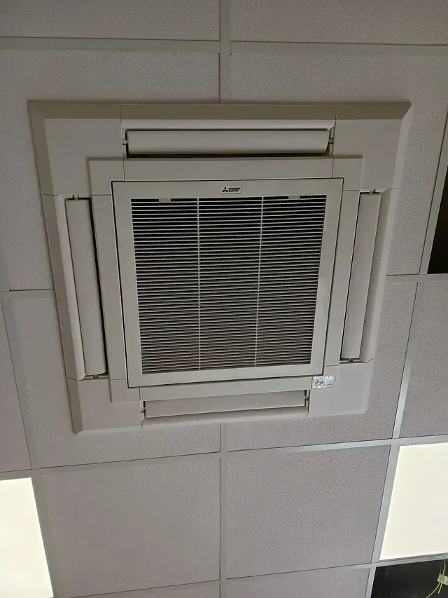 Un acondicionador de aire blanco cuelga del techo de una habitación.