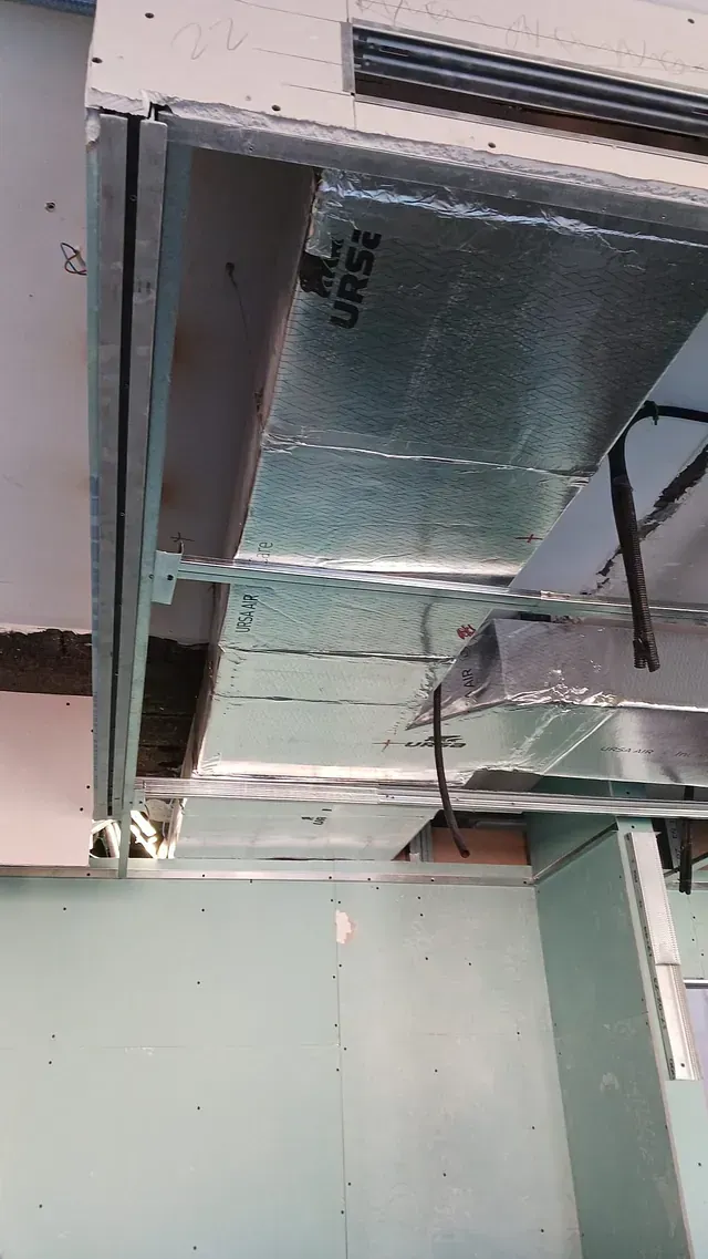 Un conducto metálico cuelga del techo de una habitación.