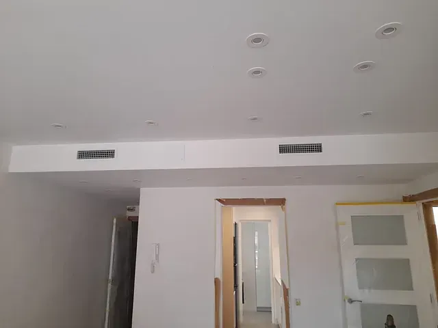 Una sala de estar con un ventilador de techo y una puerta.