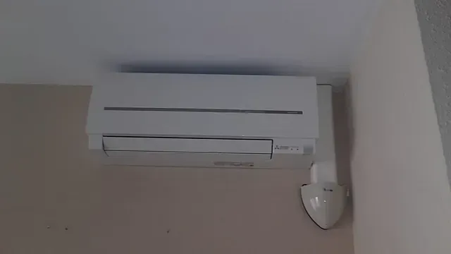 Un acondicionador de aire blanco cuelga del techo de una habitación.