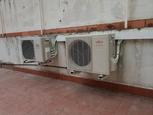 Dos acondicionadores de aire están montados en el lateral de un edificio.